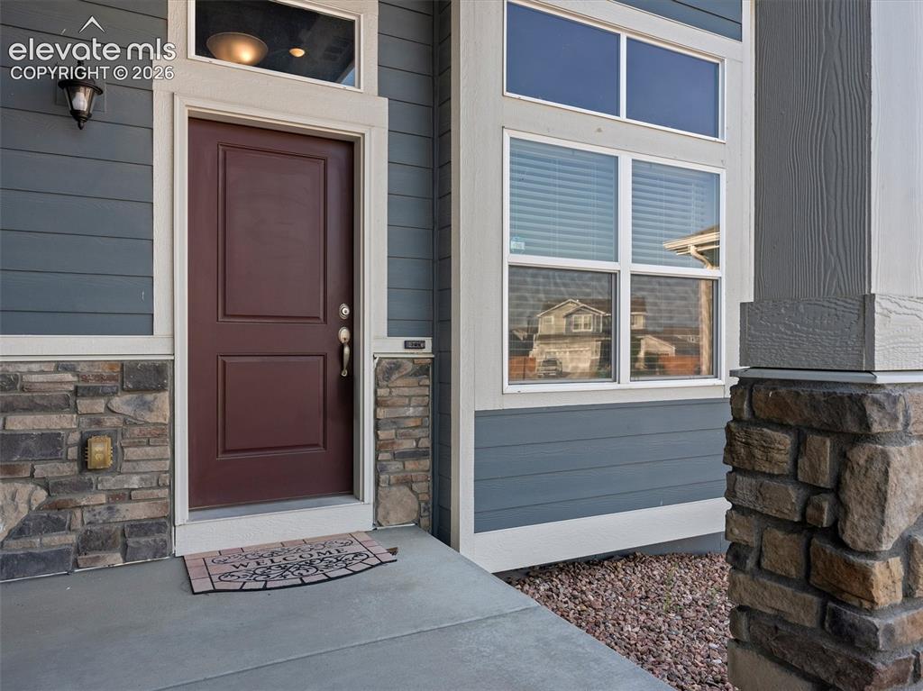 Image 5 of 46: Entryway featuring a rich brown door with panel detailing, complemented by 