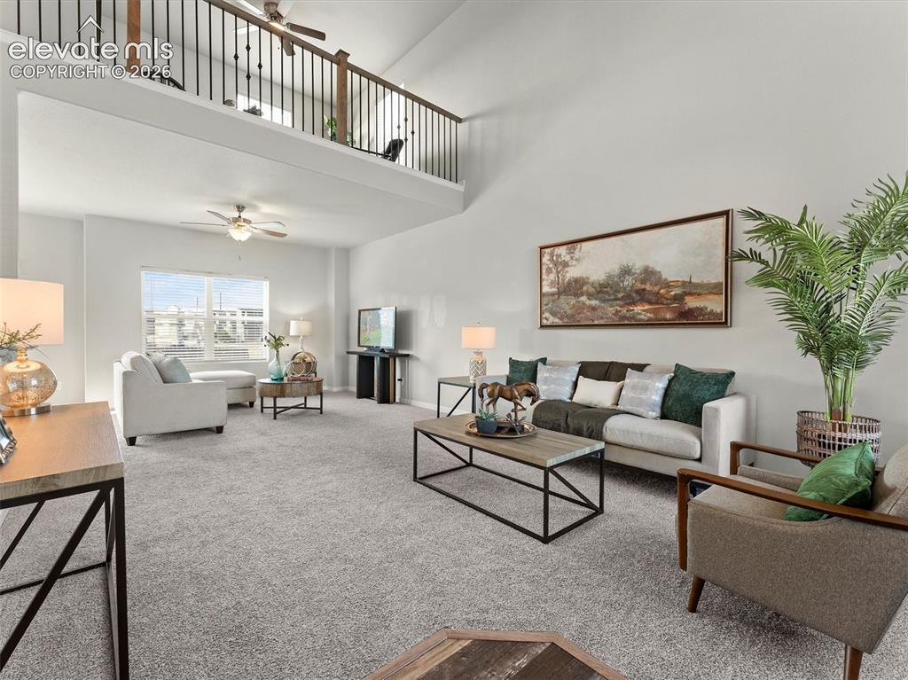 Image 6 of 46: Great room featuring a high vaulted ceiling, an upper-level balcony with me