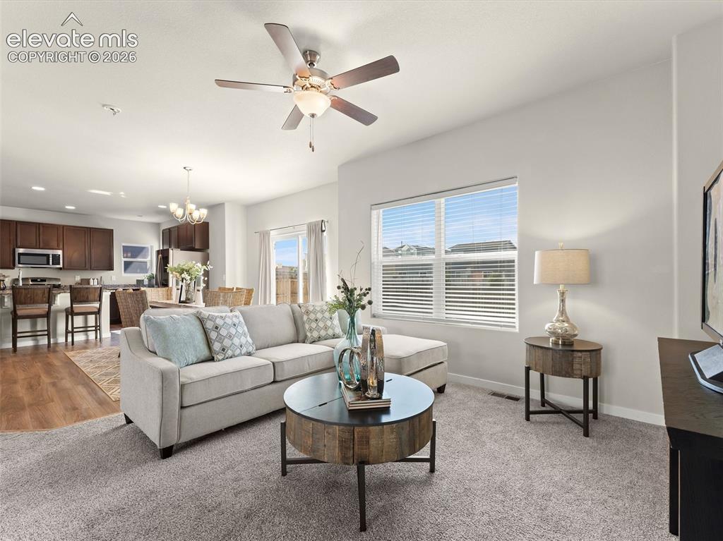 Image 9 of 46: Open-concept living area featuring a ceiling fan, recessed lighting, and la
