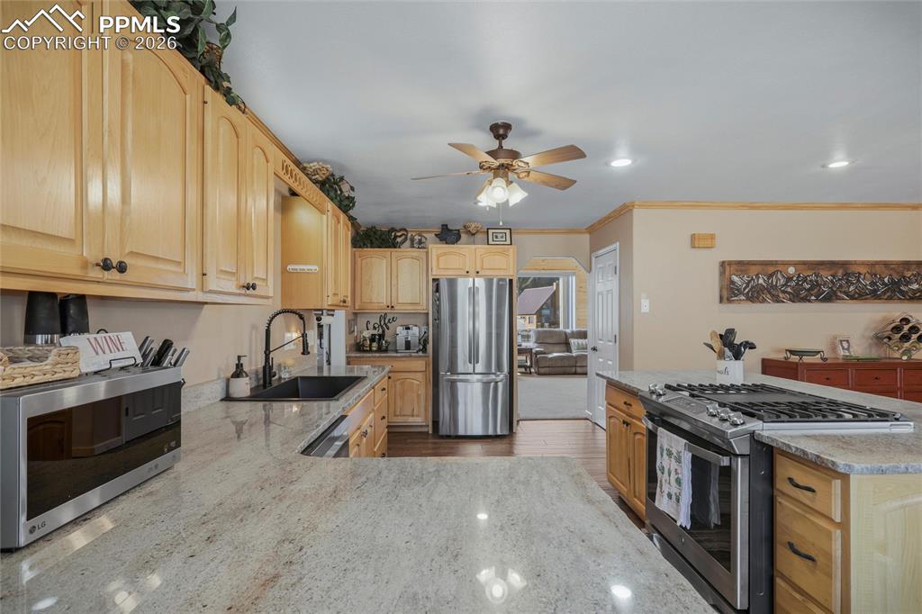Image 12 of 50: Kitchen with stainless steel appliances, light wood finish cabinets, crown 