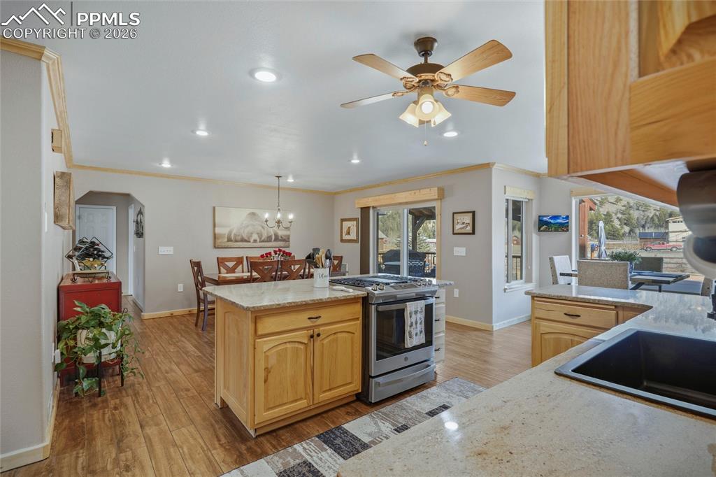 Image 14 of 50: Kitchen featuring light wood finish cabinets, light stone counters, stainle