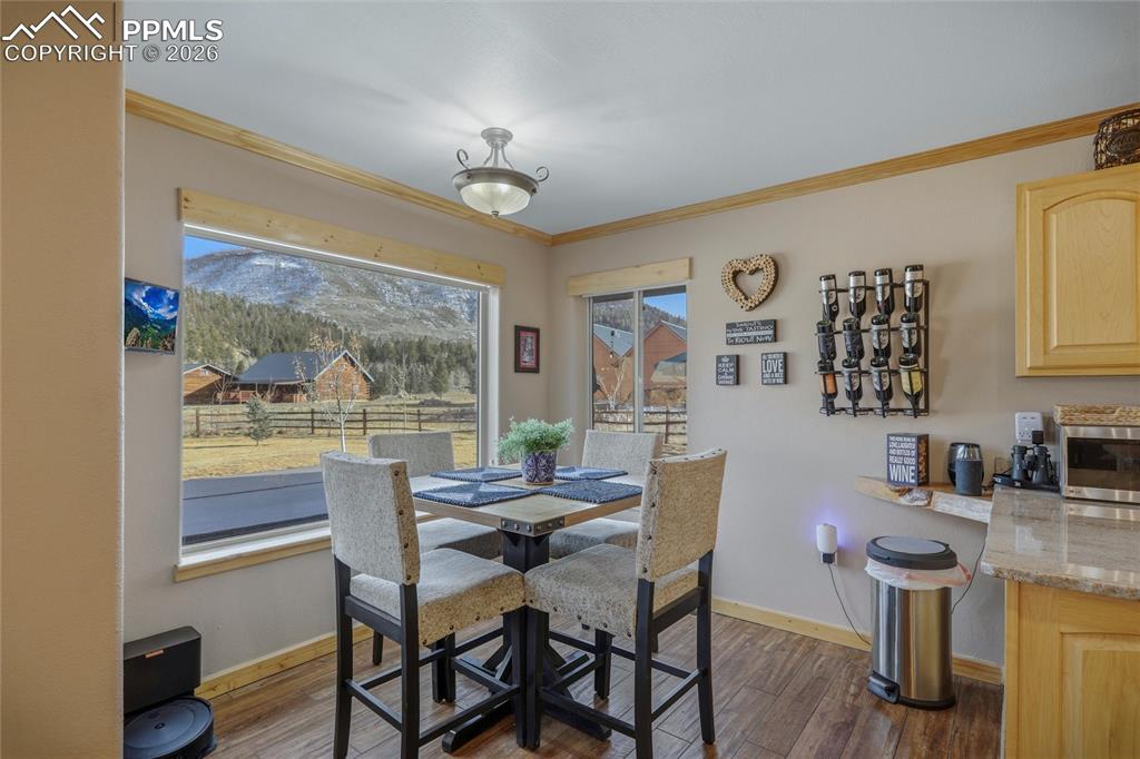Image 16 of 50: Dining space featuring ornamental molding and dark wood-type flooring