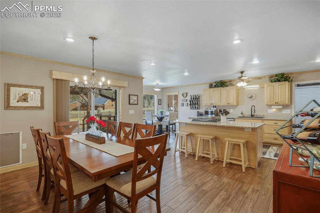 Image 18 of 50: Dining space with crown molding, dark wood finished floors, a ceiling fan, 