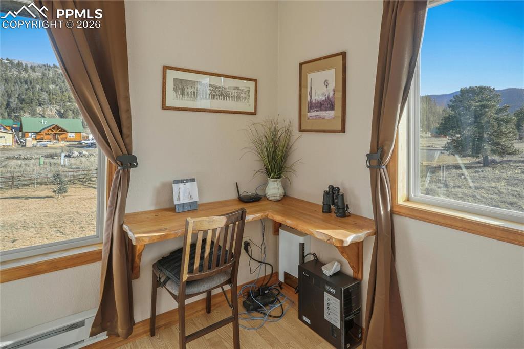 Image 28 of 50: Office space featuring baseboard heating, light wood finished floors, and p