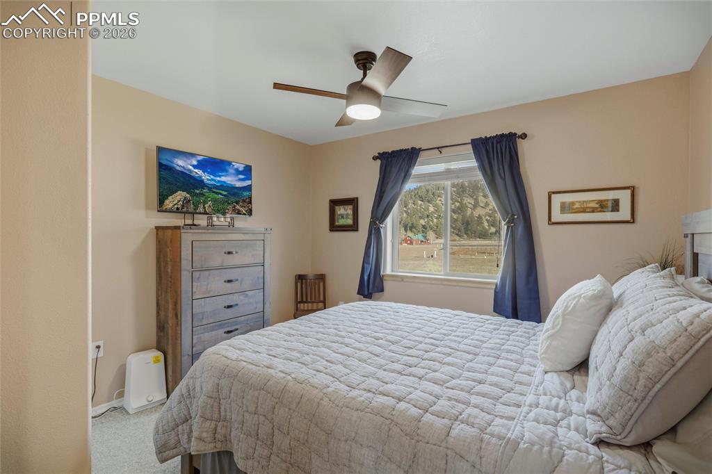 Image 34 of 50: Carpeted bedroom featuring a ceiling fan and baseboards