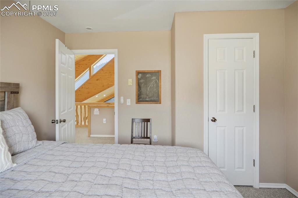 Image 35 of 50: Bedroom with light carpet and baseboards
