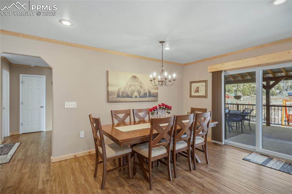 Image 36 of 50: Dining area featuring arched walkways, light wood finished floors, ornament
