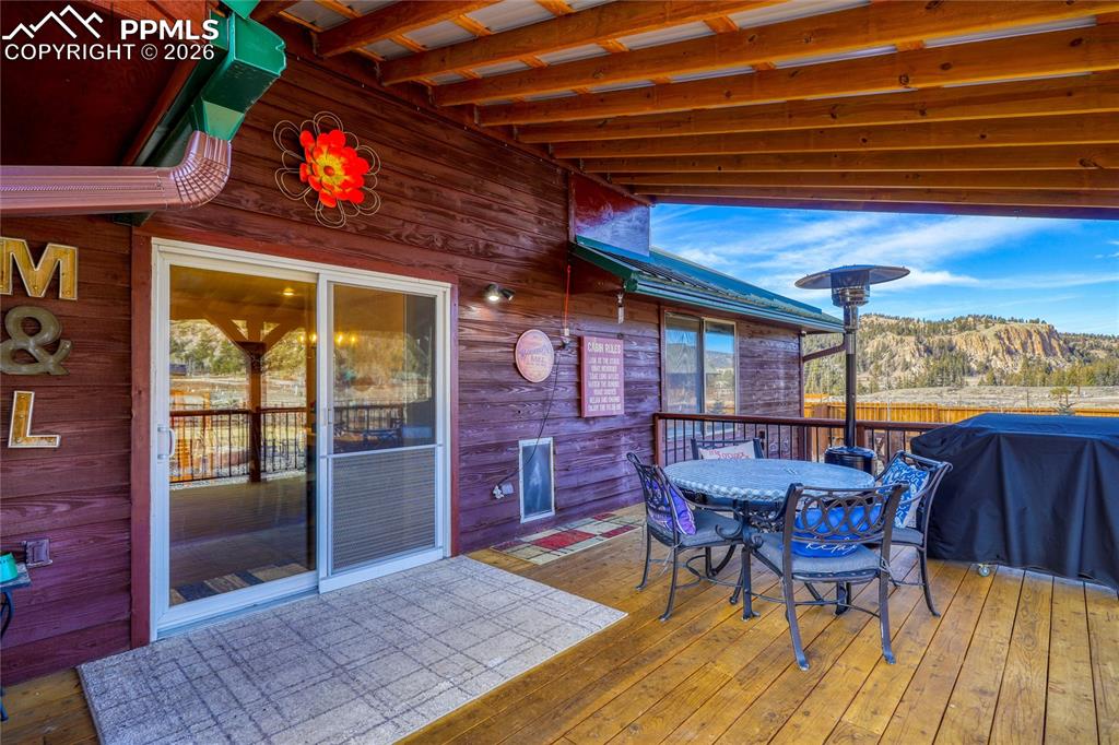 Image 37 of 50: Wooden deck with outdoor dining space and grilling area