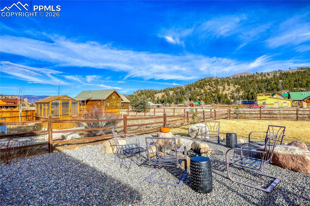 Image 42 of 50: Fenced backyard featuring an outbuilding, a mountain view, and a patio area
