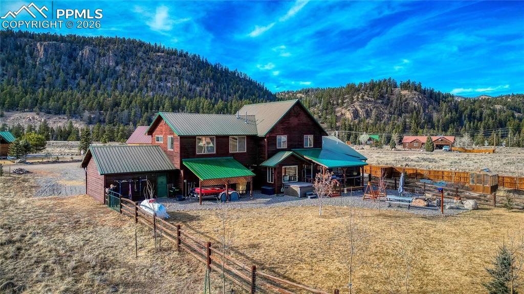 Image 46 of 50: Rustic home featuring a metal roof, a mountain view, and a forest view