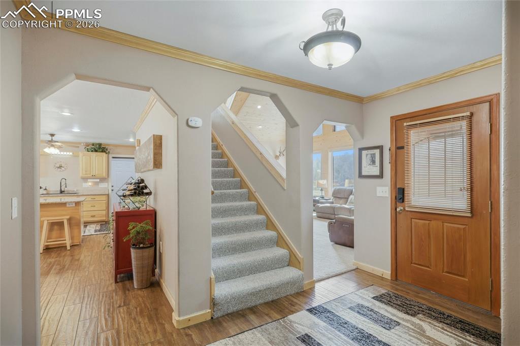 Image 9 of 50: Foyer with crown molding, wood finished floors, arched walkways, and ceilin