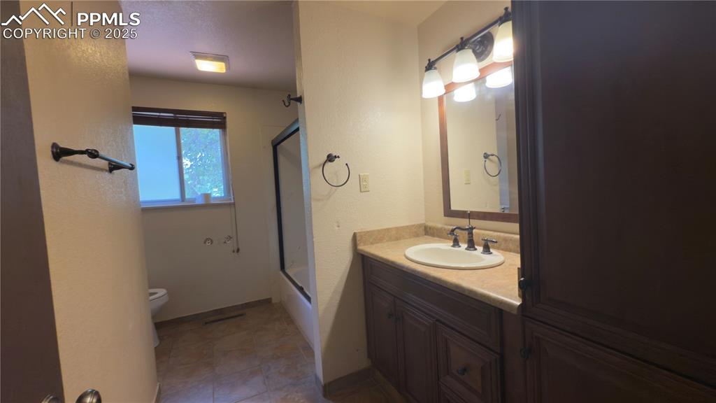 Image 14 of 17: Upper full Bathroom featuring vanity, bath / shower combo with tile floori