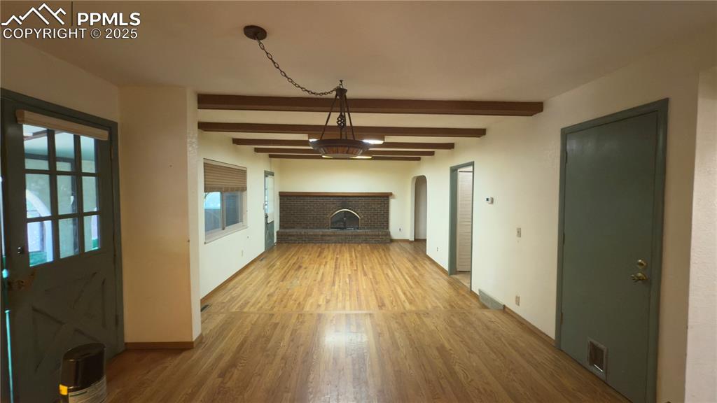 Image 7 of 17: Unfurnished living room featuring light wood finished floors and beam ceili