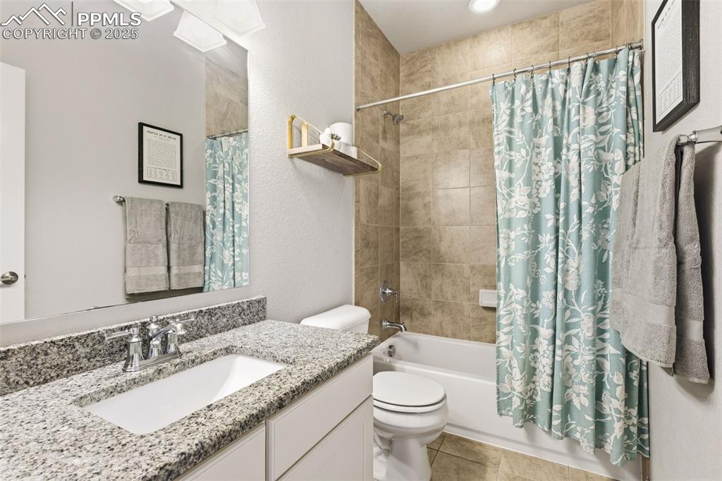 Image 23 of 34: Main level bathroom with tub/shower combo and granite counters