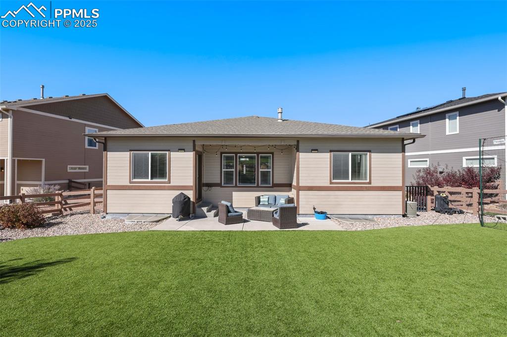Image 32 of 34: Covered patio and turf lawn