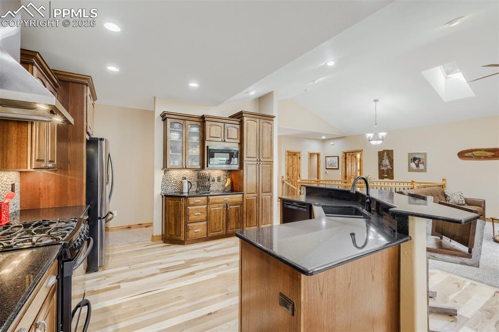 Image 10 of 49: Kitchen featuring knotty alder cabinets and hickory wood floor