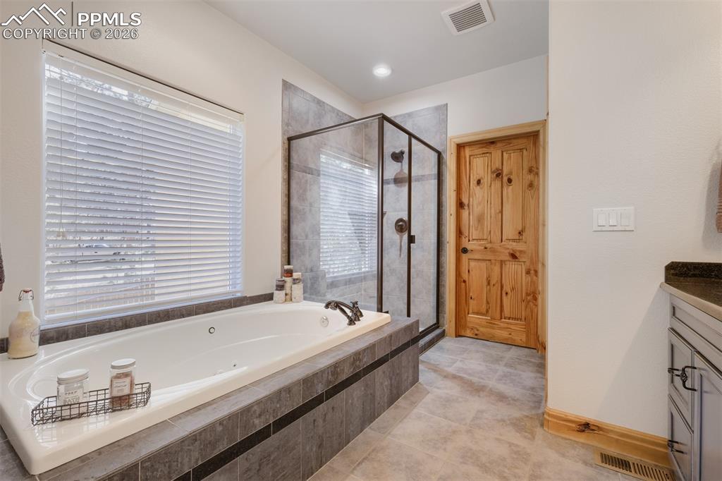 Image 18 of 49: Primary bath also features jetted soaking tub and large shower 