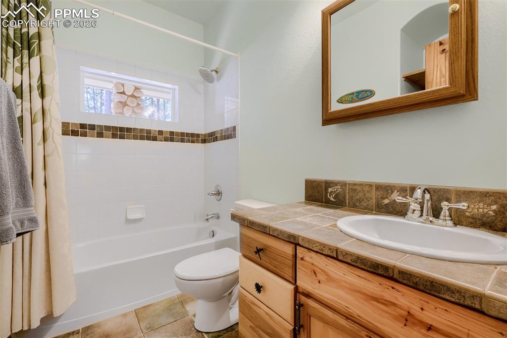 Image 20 of 49: Jr suite main level full bath featuring vanity, shower / tub combo, and lig