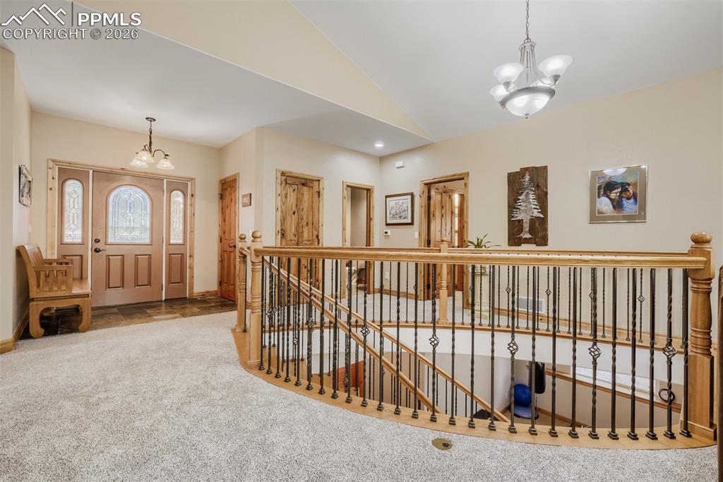 Image 5 of 49: Entrance foyer featuring vaulted ceiling, and a grand central staircase w/w