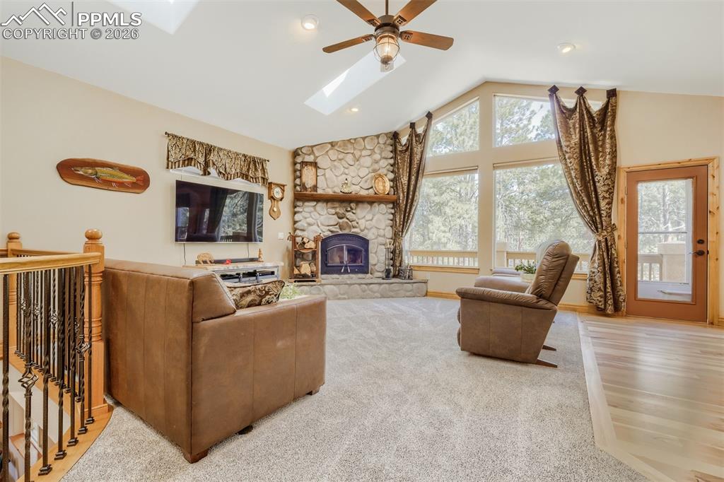 Image 7 of 49: Great room includes a stone surround wood burning FP, skylights, and floor 