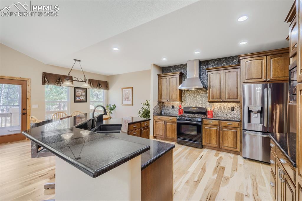 Image 9 of 49: Kitchen offers granite slab counters, breakfast bar, 42” uppers w/crown, re