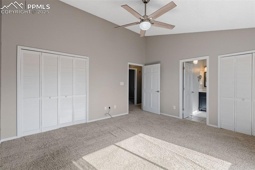 Image 14 of 33: Unfurnished bedroom featuring light carpet, connected bathroom, a ceiling f