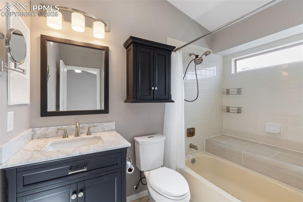 Image 15 of 33: Bathroom featuring shower / bath combo and vanity