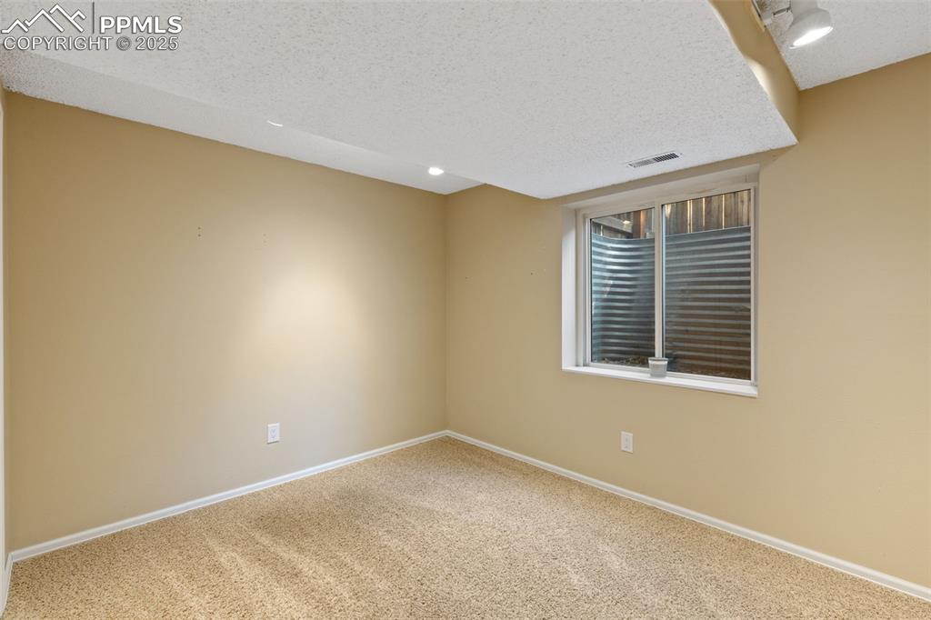 Image 16 of 33: Unfurnished room featuring a textured ceiling, carpet flooring, and recesse