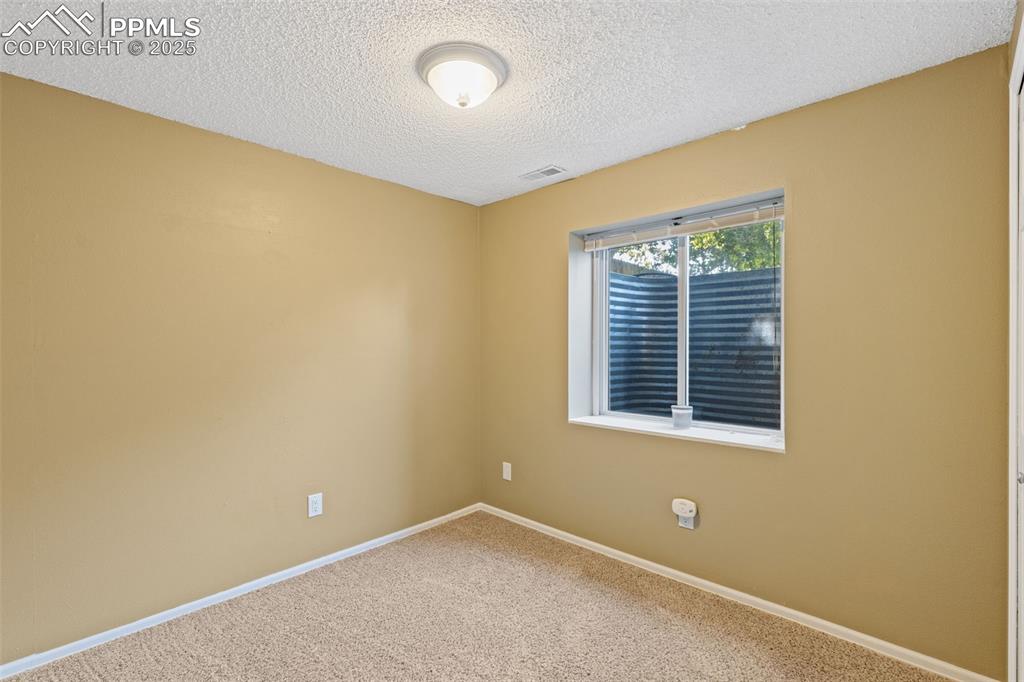 Image 17 of 33: Carpeted empty room featuring baseboards and a textured ceiling