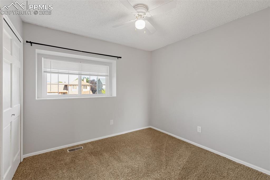 Image 19 of 33: Carpeted spare room featuring a textured ceiling and a ceiling fan