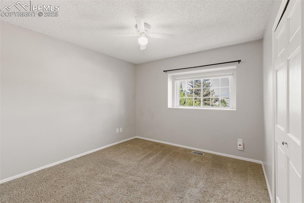 Image 20 of 33: Unfurnished bedroom featuring a closet, carpet flooring, a textured ceiling
