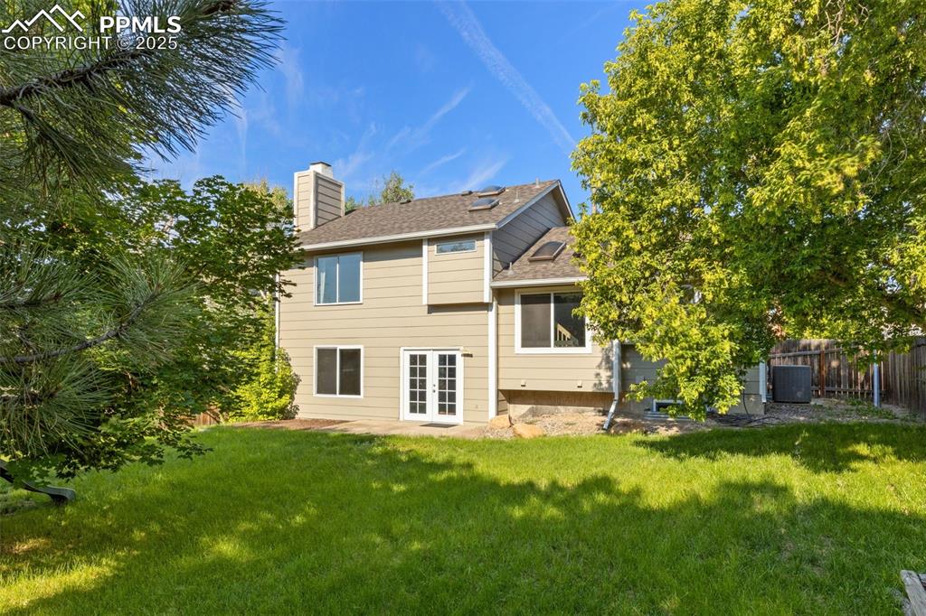 Image 25 of 33: Rear view of property with a chimney, a lawn, a patio, and french doors