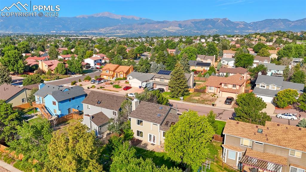 Image 27 of 33: Aerial view of residential area with a mountain backdrop