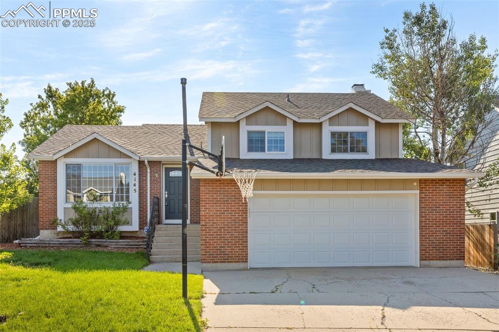 Image 29 of 33: View of front of home with board and batten siding, a shingled roof, a gara