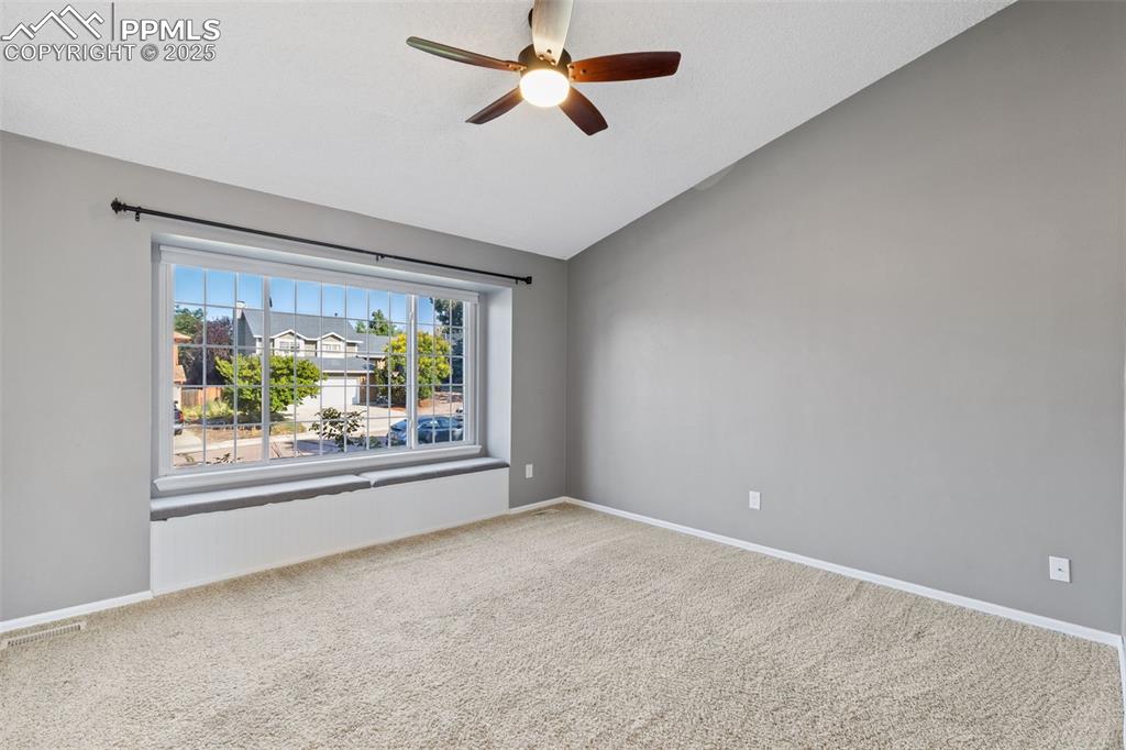 Image 3 of 33: Empty room featuring lofted ceiling, carpet floors, and a ceiling fan