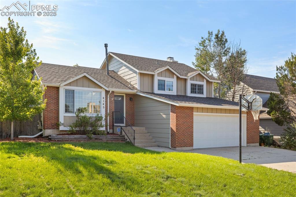Image 30 of 33: View of front facade with board and batten siding, a shingled roof, drivewa