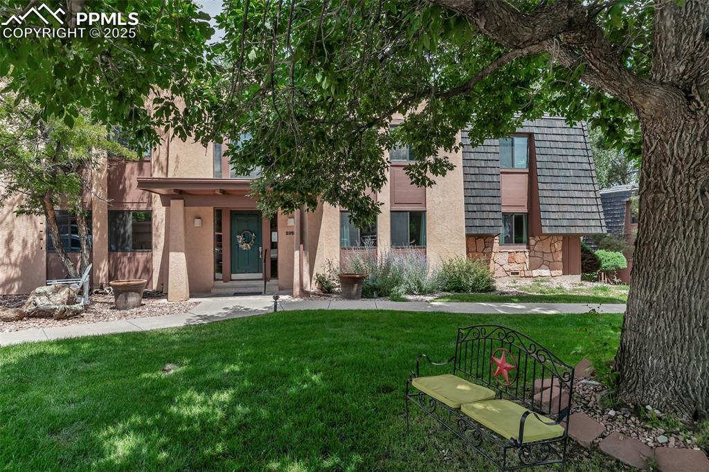 Image 31 of 37: View of front facade with stone siding, a front lawn, and stucco siding