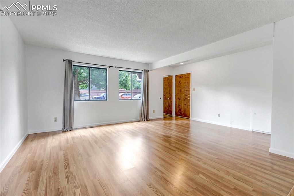 Image 8 of 37: Family Room looking back at front door and large south facing windows.