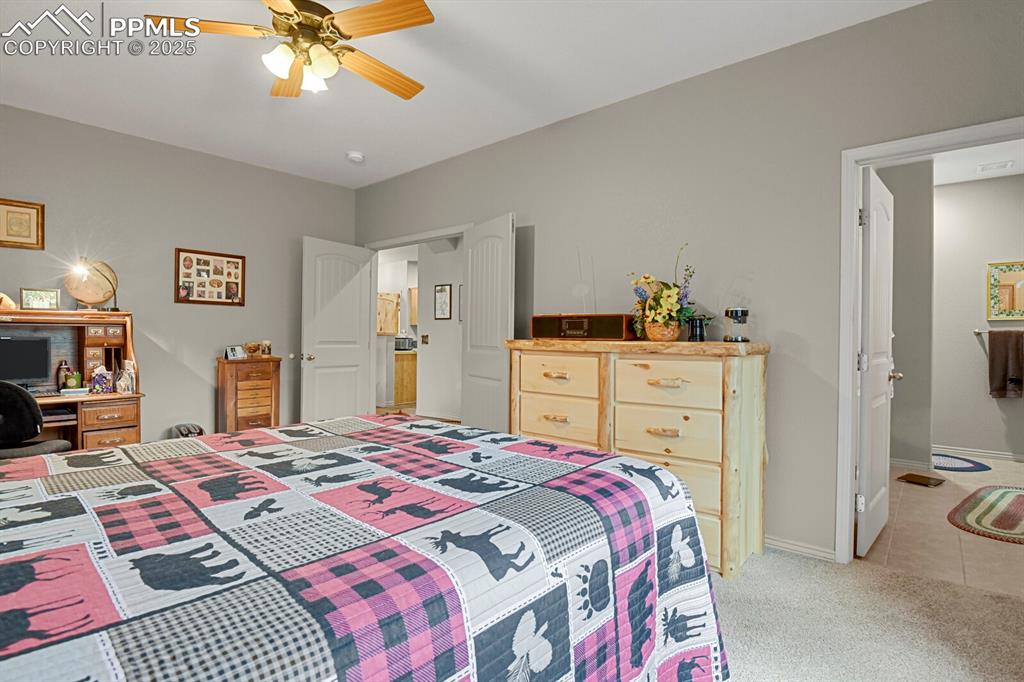 Image 15 of 43: Bedroom featuring light carpet, ceiling fan, and light tile patterned floor