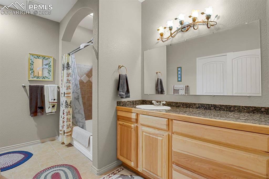 Image 16 of 43: Bathroom featuring vanity, tile patterned floors, and shower / tub combo