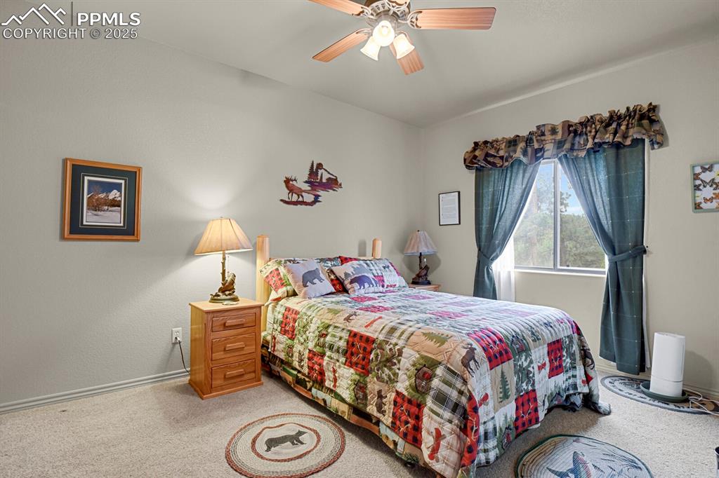 Image 20 of 43: Bedroom with light carpet and a ceiling fan