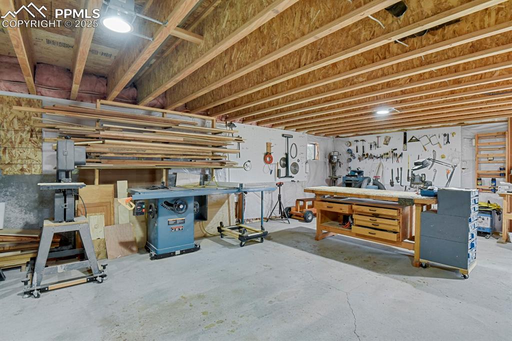 Image 24 of 43: Below grade area with a workshop area