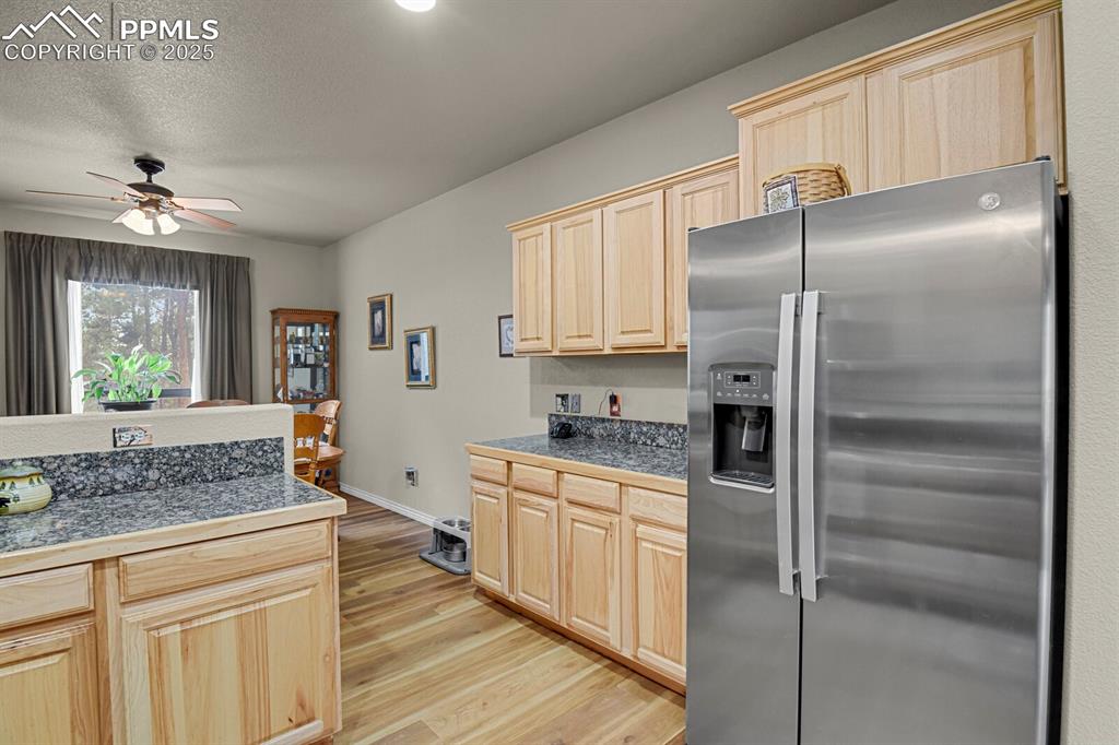 Image 4 of 43: Kitchen featuring tile countertops, stainless steel refrigerator with ice d