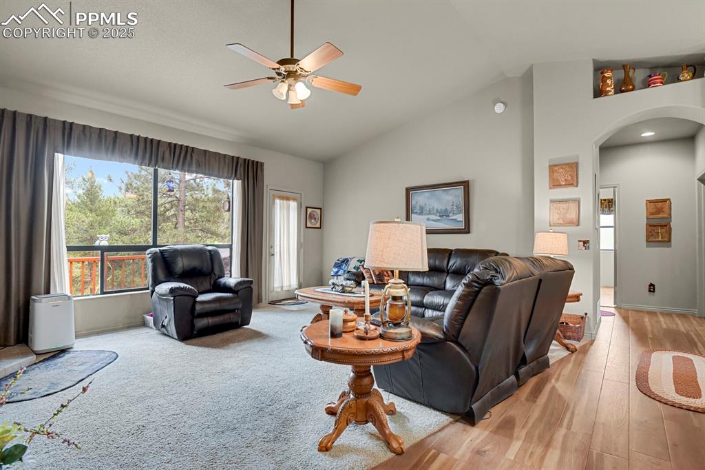 Image 9 of 43: Living area with arched walkways, lofted ceiling, a ceiling fan, and light
