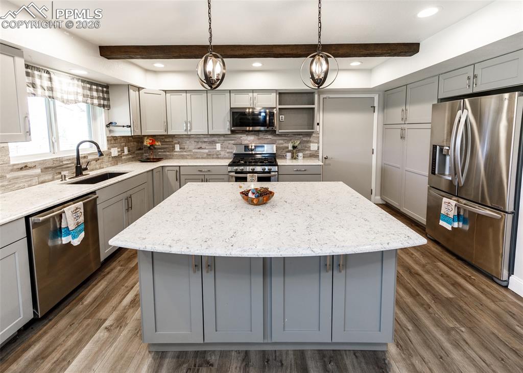 Image 10 of 39: Quartz counters, stone backsplash & stainless steel appliances