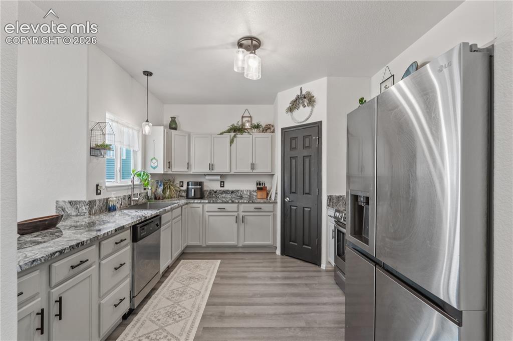 Image 10 of 41: Vaulted ceiling with a wood-finish ceiling fan, wood-finish flooring, and l