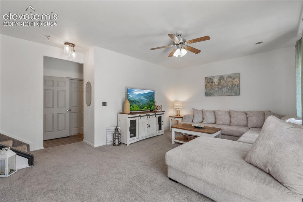 Image 17 of 41: Living area featuring a ceiling fan with light fixture, light gray carpetin