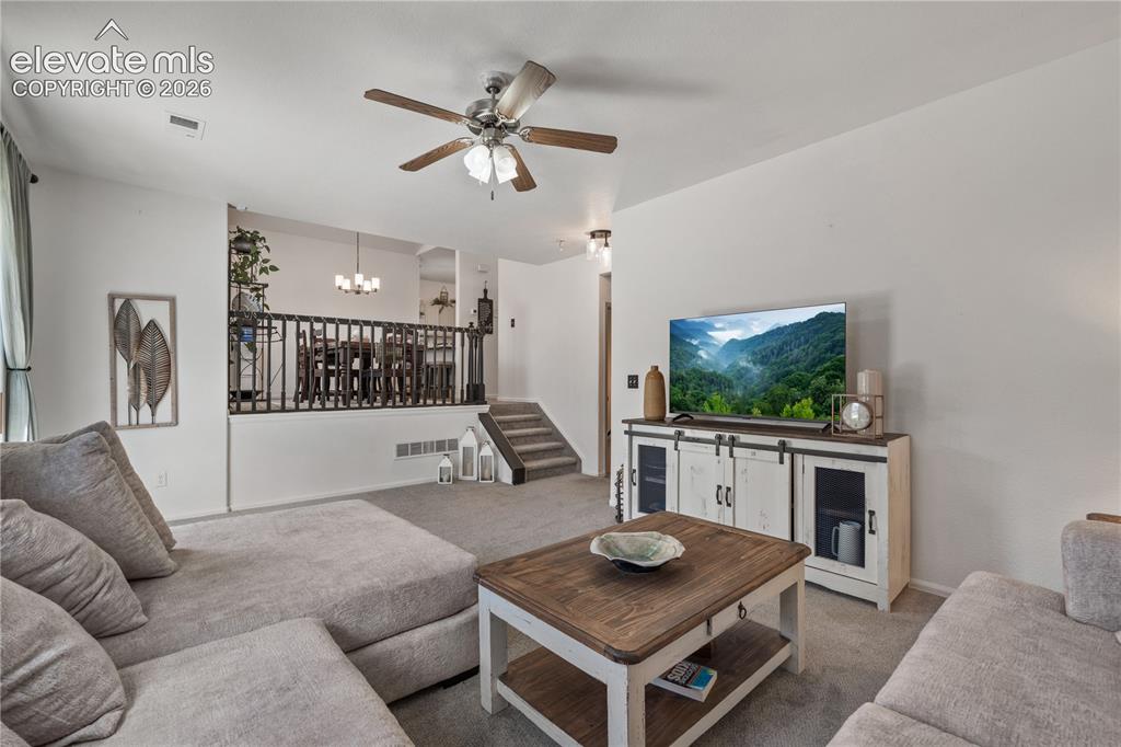 Image 18 of 41: Spacious living area featuring light gray carpeting and white walls