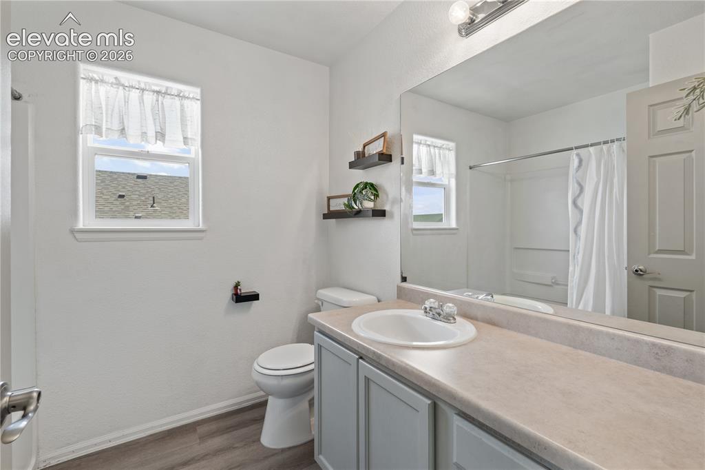 Image 29 of 41: Carpeted bedroom featuring a white paneled door, bi-fold closet doors, and