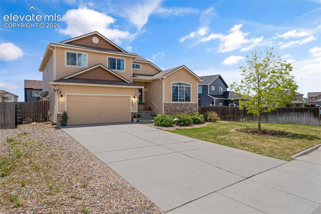 Image 3 of 41: Two-story residence featuring a two-car garage, stone facade accents, and a